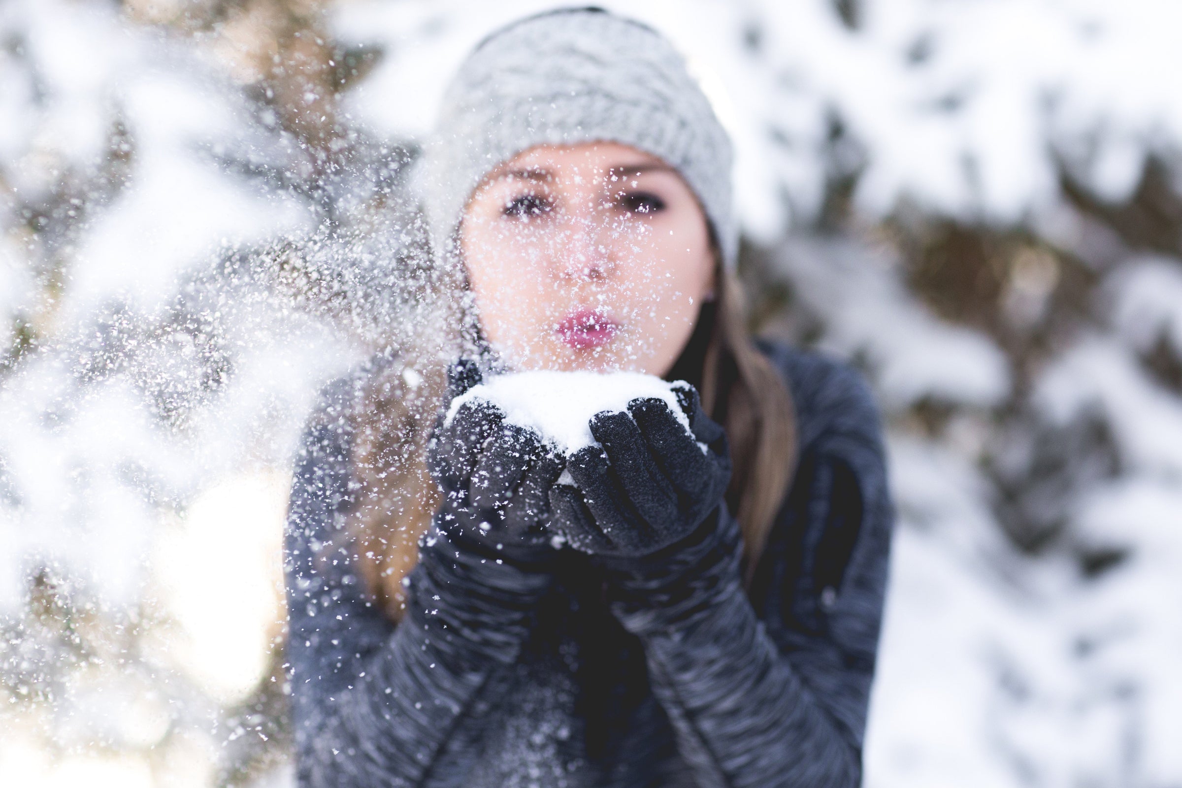 Woman blowing snow from her hands